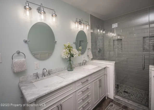 a bathroom with a granite countertop double vanity sink and mirror