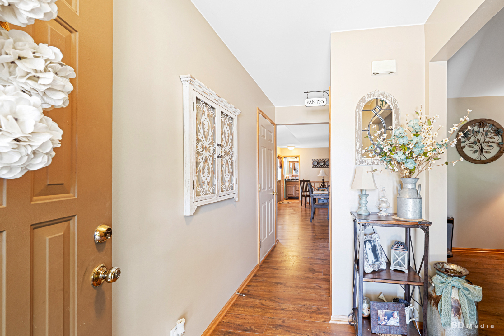 2018 Olde Mill Road Plainfield, IL 60586 - Photo 3 of 30 a hallway with a dining table wooden floor and a chandelier