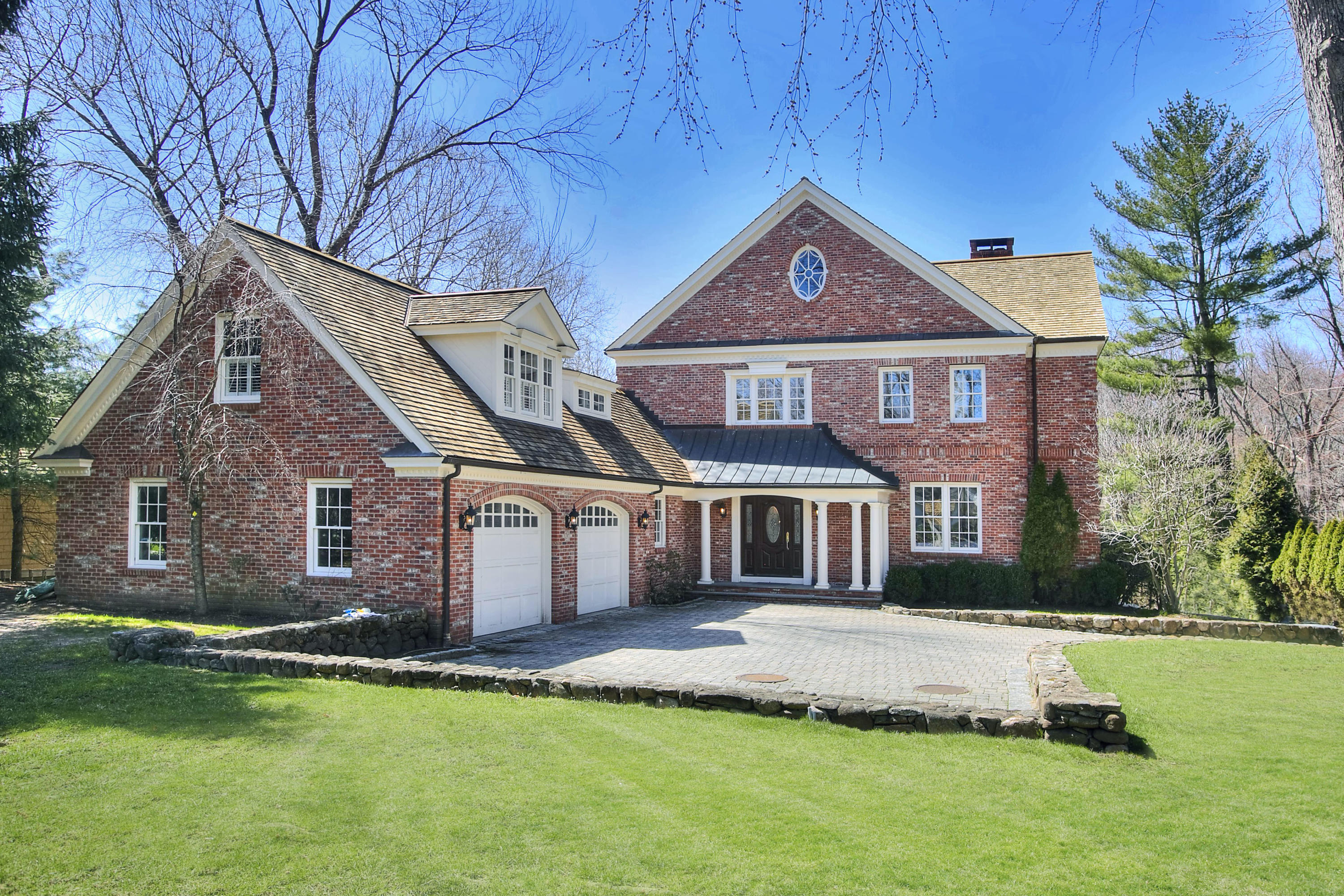 320 Ponus Ridge Road New Canaan, CT 06840 - Photo 1 of 40 a front view of a house with a garden and yard