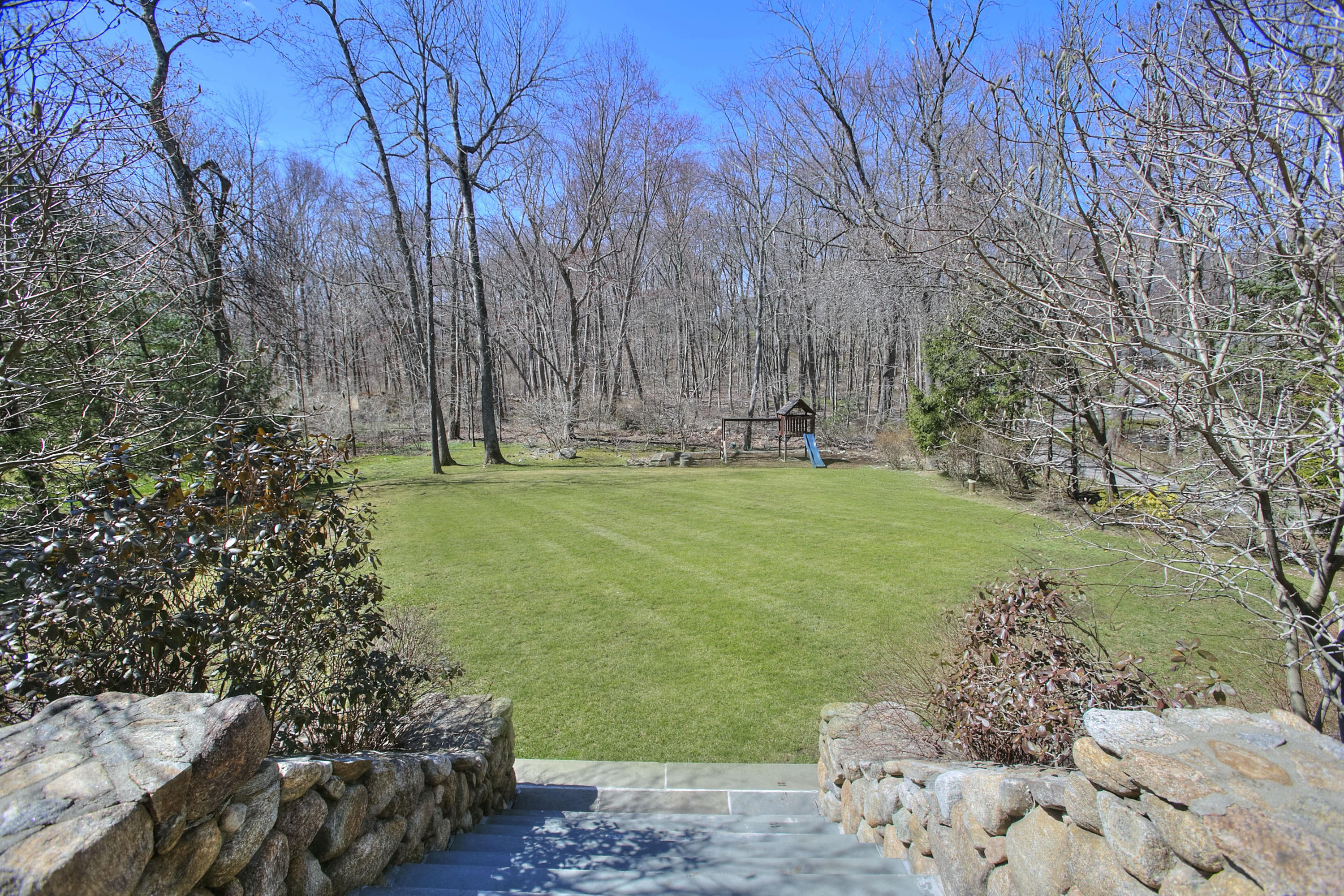 320 Ponus Ridge Road New Canaan, CT 06840 - Photo 35 of 40 a backyard with tall trees