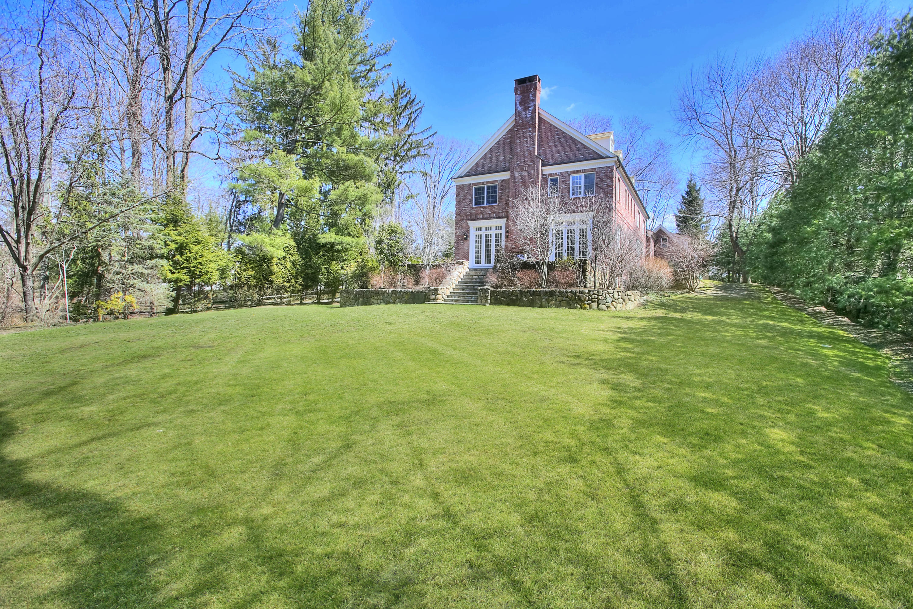 320 Ponus Ridge Road New Canaan, CT 06840 - Photo 36 of 40 a front view of a house with yard and green space