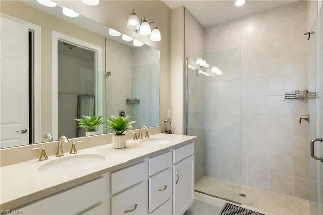a bathroom with a double vanity sink mirror and shower