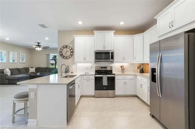 a kitchen with a sink stainless steel appliances and white cabinets