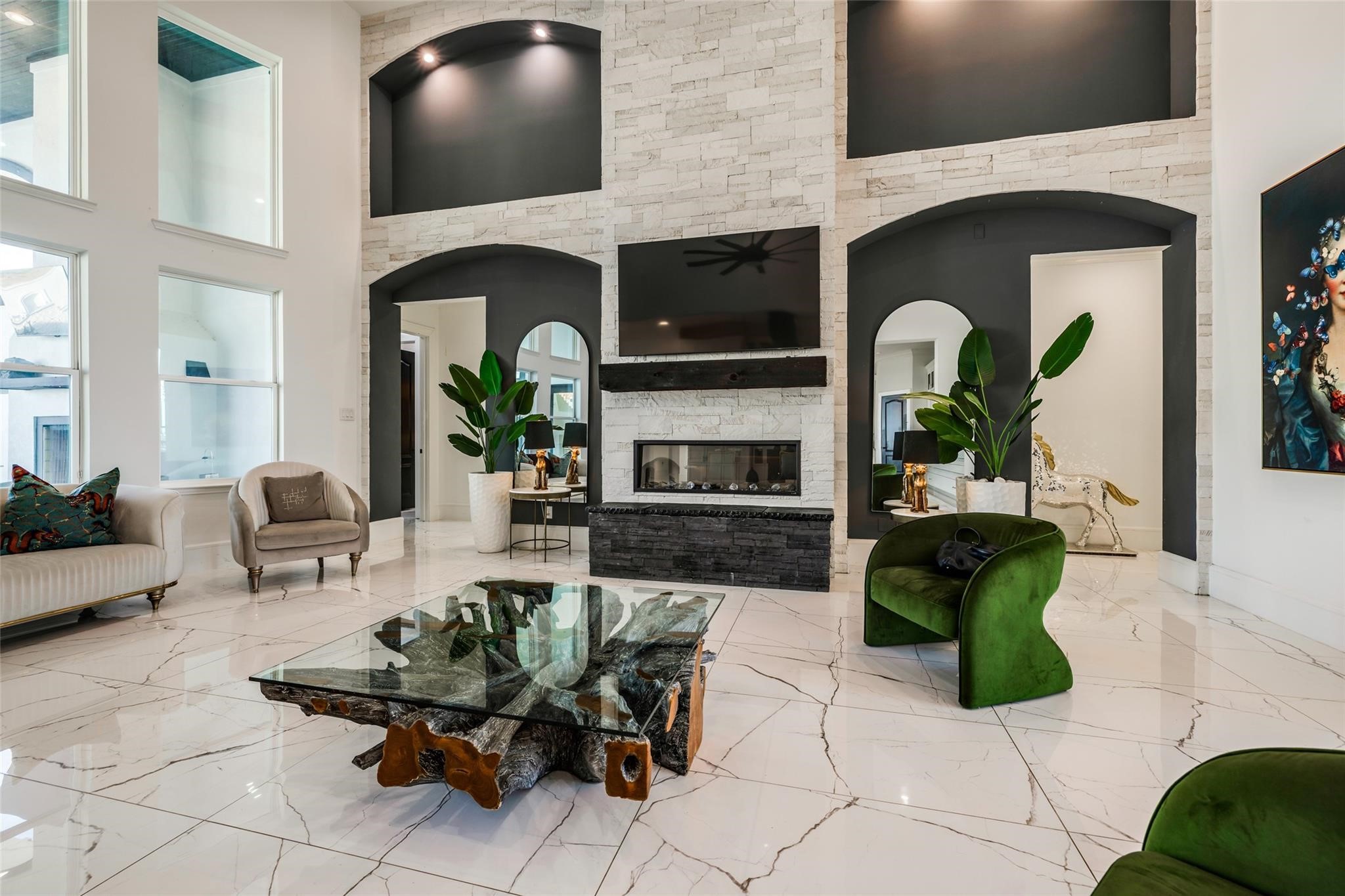 4821 Walters Road Richmond, TX 77469 - Photo 19 of 50 a perfect blend of modern luxury and warmth, highlighted by soaring vaulted ceilings with exposed beams, oversized windows that flood the home with natural light, and elegant designer finishes throughout. The open-concept layout features a striking floor-to-ceiling fireplace, custom built-ins, and seamless flow into the gourmet kitchen and dining areas, creating an ideal setting for both everyday living and entertaining. Thoughtfully curated furnishings, rich wood accents, and sophisticated lighting