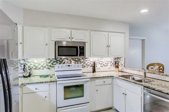 a kitchen with stainless steel appliances granite countertop a sink stove and microwave