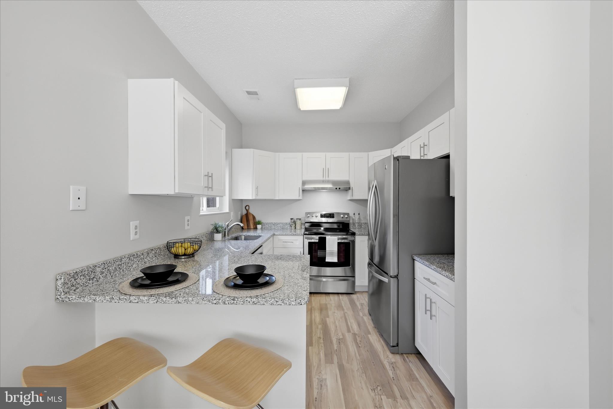 1907 Villaridge Drive Reston, VA 20191 - Photo 2 of 32 a kitchen with a refrigerator a stove and a cabinets