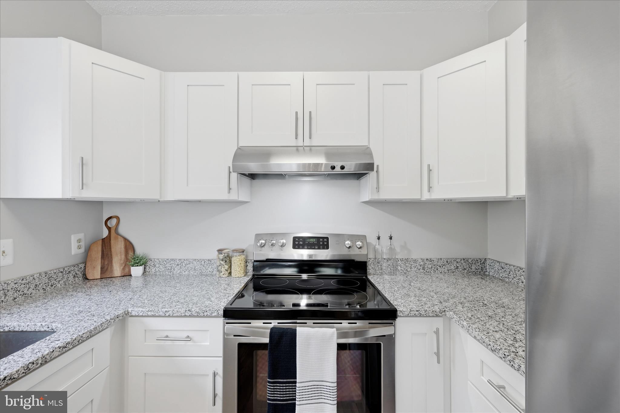 1907 Villaridge Drive Reston, VA 20191 - Photo 4 of 32 a kitchen with granite countertop white cabinets and stainless steel appliances