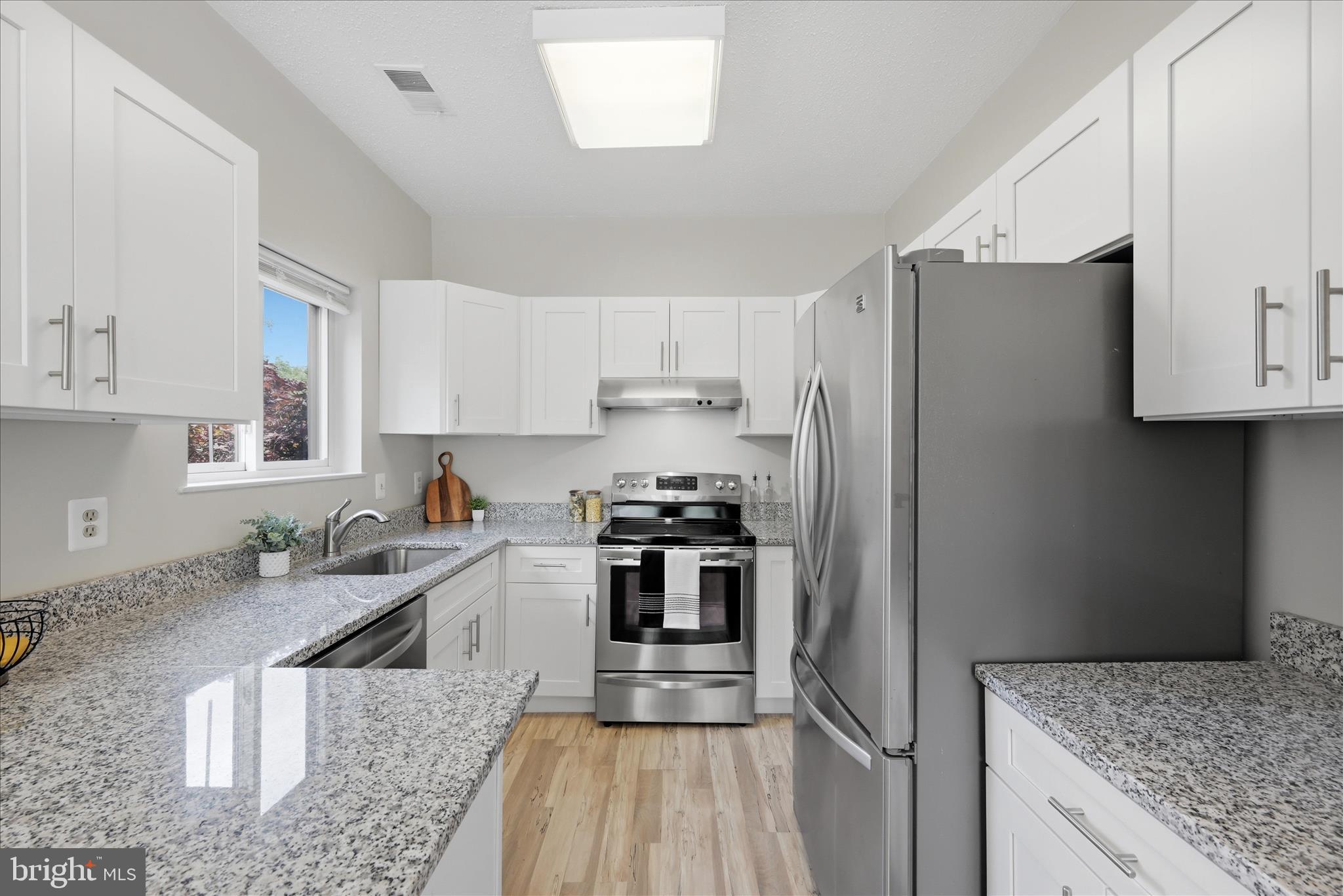 1907 Villaridge Drive Reston, VA 20191 - Photo 5 of 32 a kitchen with stainless steel appliances granite countertop a sink stove and refrigerator