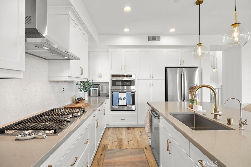 26 Yerra Street Rancho Mission Viejo, CA 92694 - Photo 35 of 75 a kitchen with kitchen island stainless steel appliances a sink a stove a refrigerator and cabinets