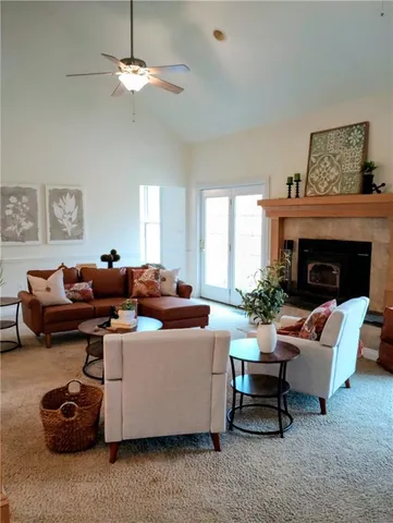 a living room with furniture a chandelier and a fireplace