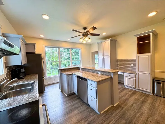 a kitchen with stainless steel appliances granite countertop a stove and a refrigerator