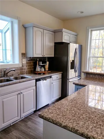 a kitchen with stainless steel appliances granite countertop a sink stove and refrigerator