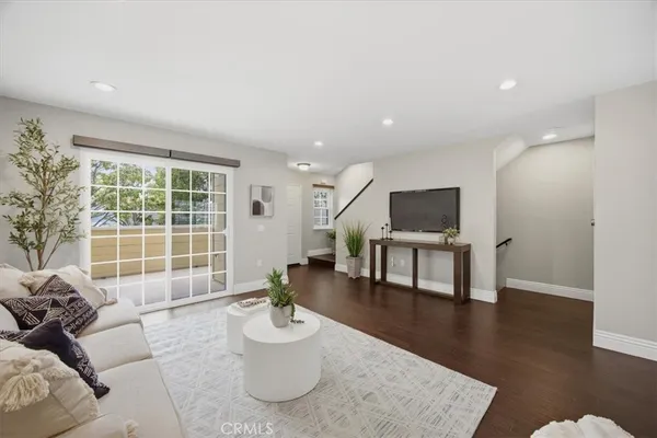 a living room with furniture and a table with wooden floor