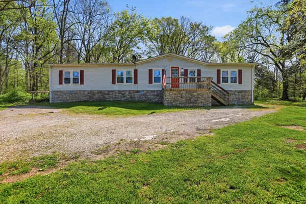 a front view of a house with a yard and trees