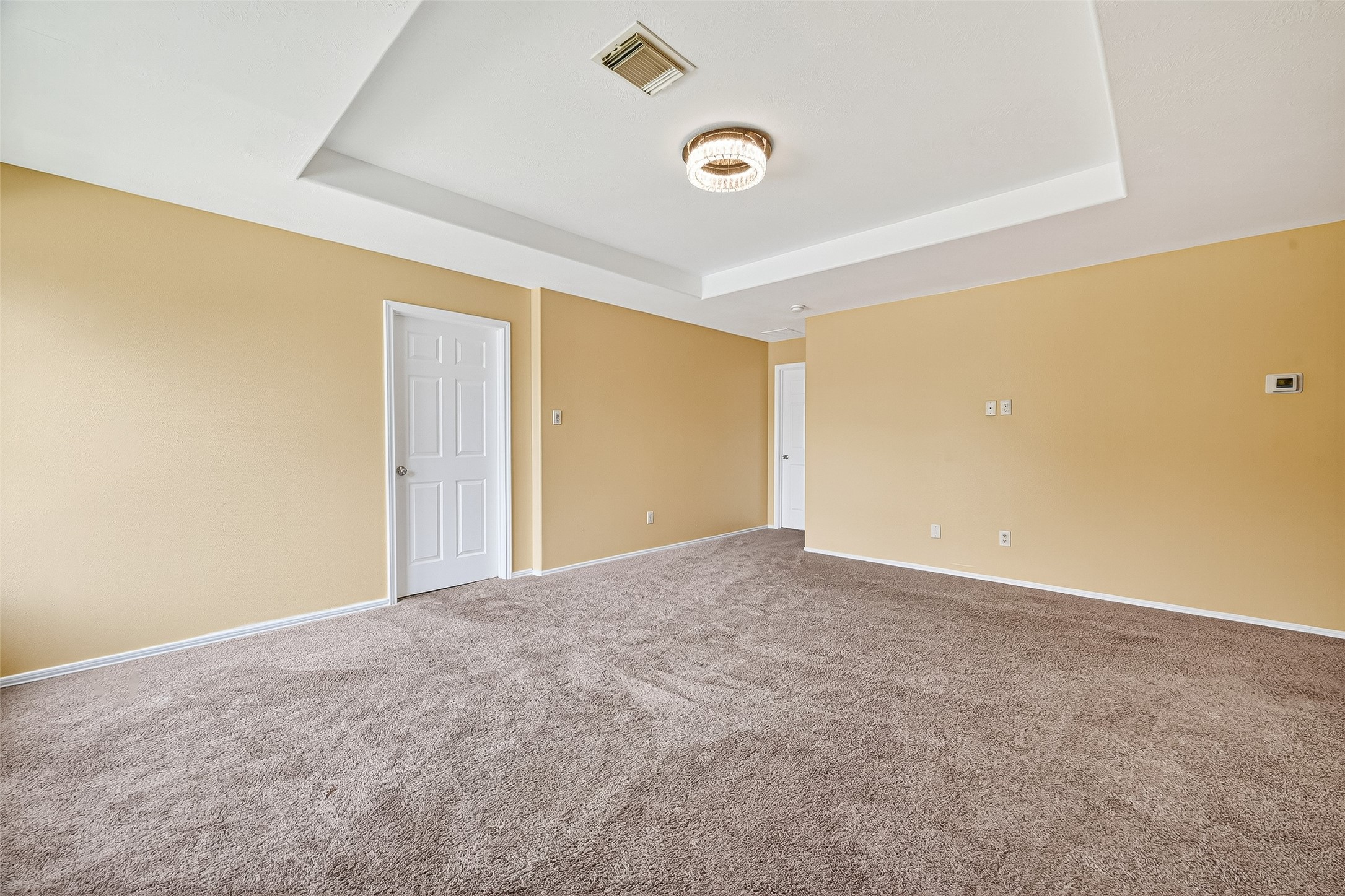 634 Hawthorne Pasture Road Rosenberg, TX 77471 - Photo 24 of 49 Expansive game room with a tray ceiling, offering a refined space for entertainment and relaxation.