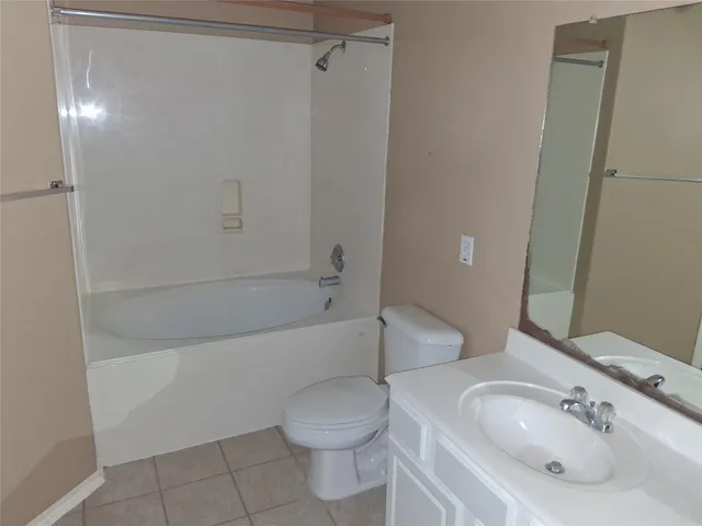 an empty room with wooden floor chandelier fan and windows