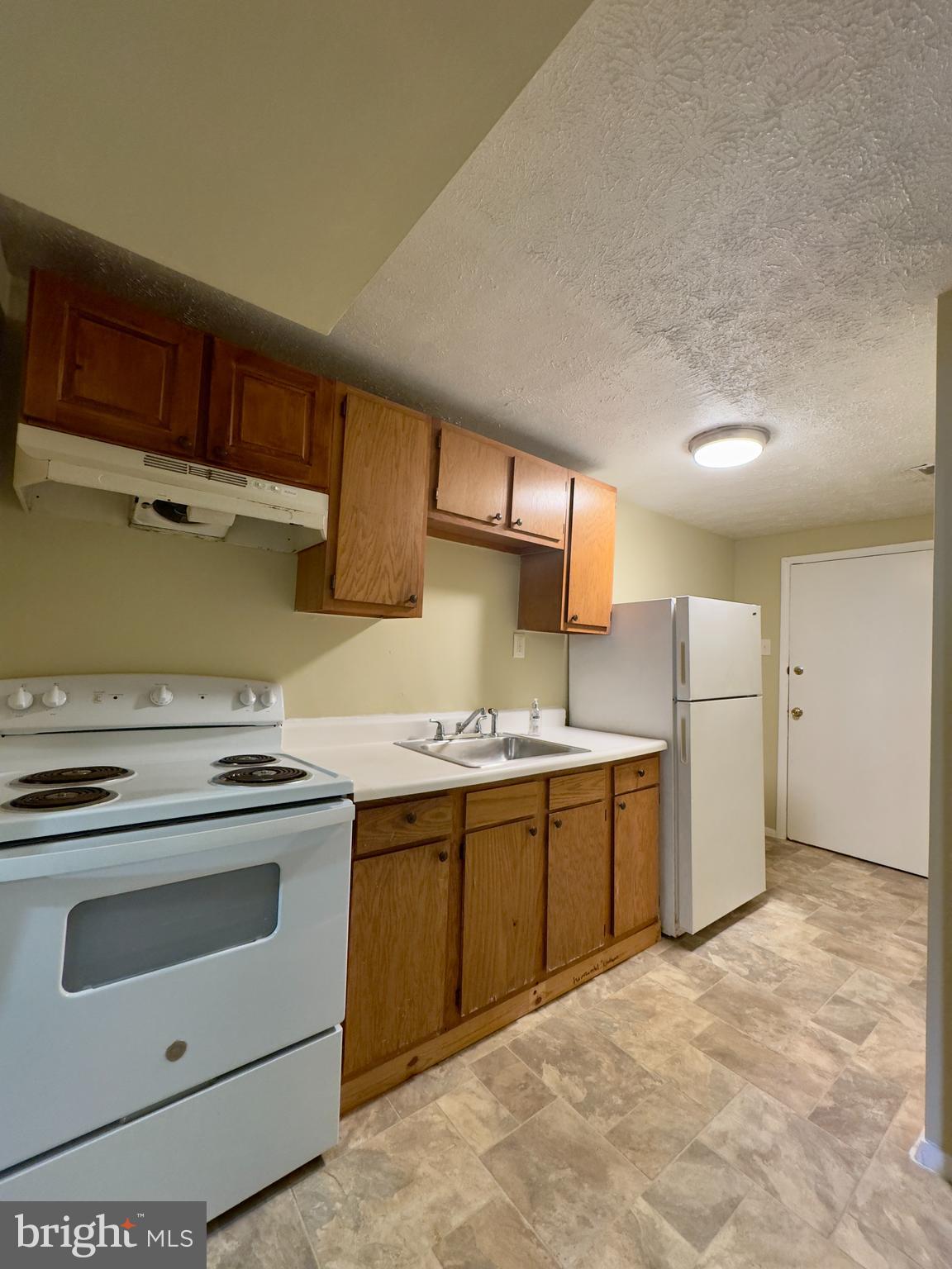 1503 Eutaw Place, Unit B1 Baltimore, MD 21217 - Photo 2 of 7 a kitchen with a stove sink and cabinets