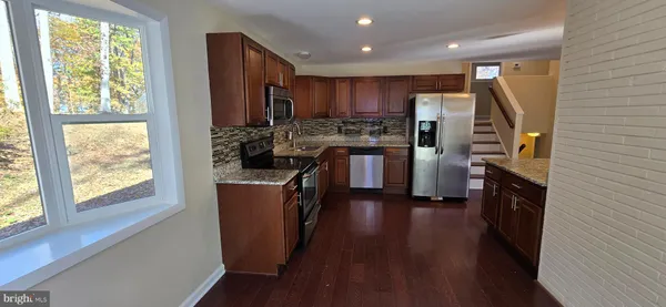 a kitchen with stainless steel appliances granite countertop a refrigerator and a stove