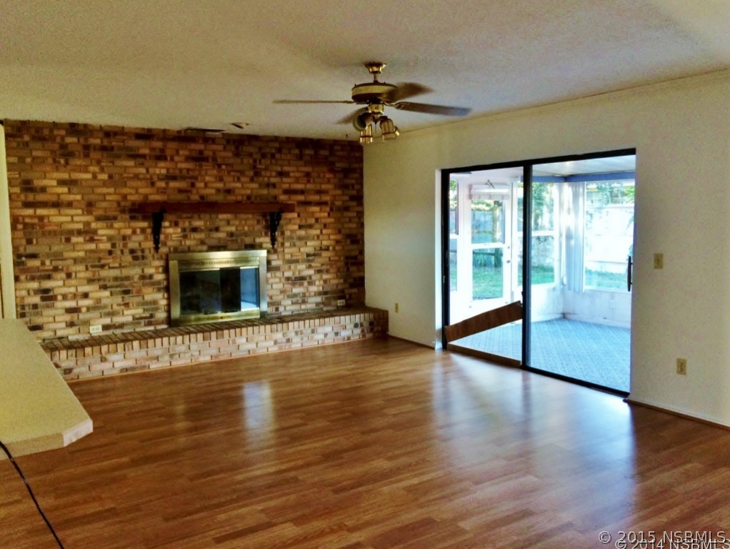 509 Cardinal Drive Edgewater, FL 32141 - Photo 5 of 10 a view of an empty room with wooden floor fireplace and a window