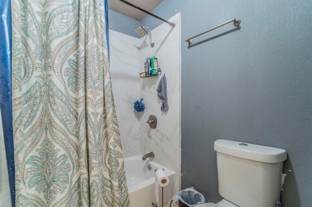 3934 Harlingen Street Dallas, TX 75212 - Photo 17 of 26 a bathroom with a toilet and shower curtain