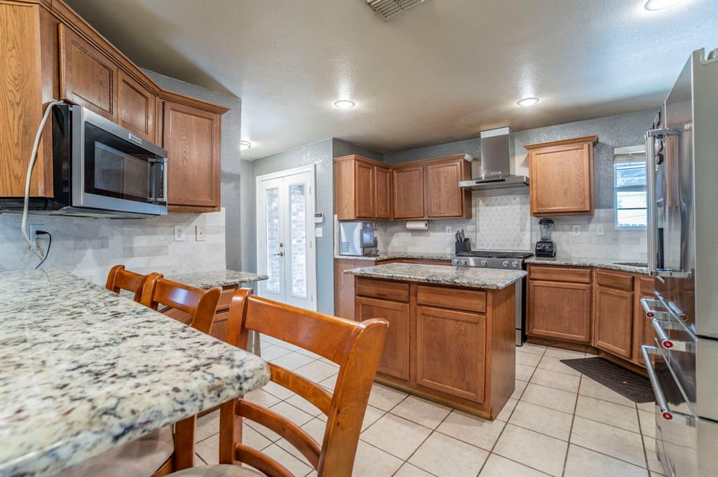 3934 Harlingen Street Dallas, TX 75212 - Photo 8 of 26 a kitchen with stainless steel appliances granite countertop a stove top oven a sink a dining table and chairs
