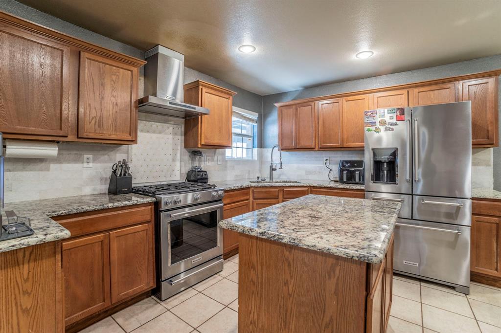 3934 Harlingen Street Dallas, TX 75212 - Photo 9 of 26 a kitchen with granite countertop stainless steel appliances a stove refrigerator and cabinets