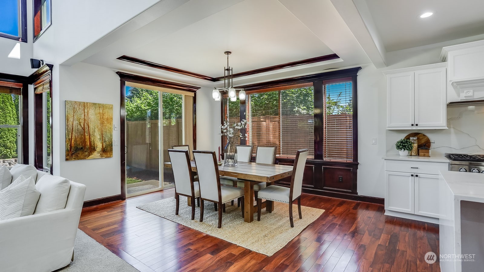 1152 Queen Avenue Northeast Renton, WA 98056 - Photo 13 of 40 a dining room with wooden floor a chandelier a glass table and chairs