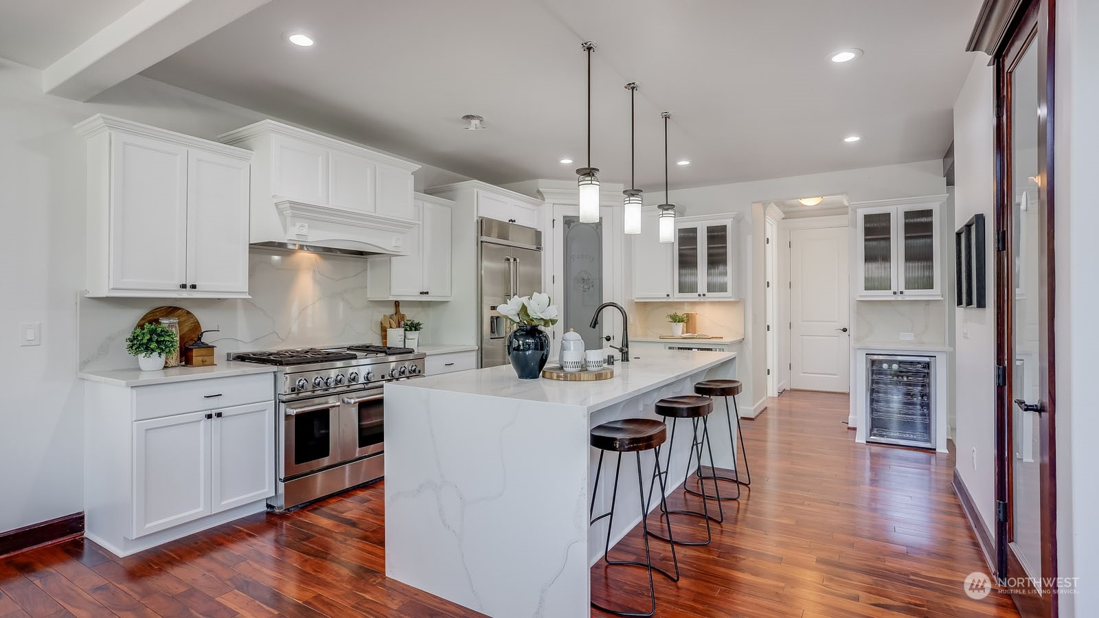 1152 Queen Avenue Northeast Renton, WA 98056 - Photo 18 of 40 a kitchen with stainless steel appliances kitchen island wooden floors stove and white cabinets
