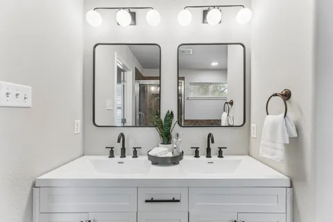 a bathroom with double vanity sinks and a mirror