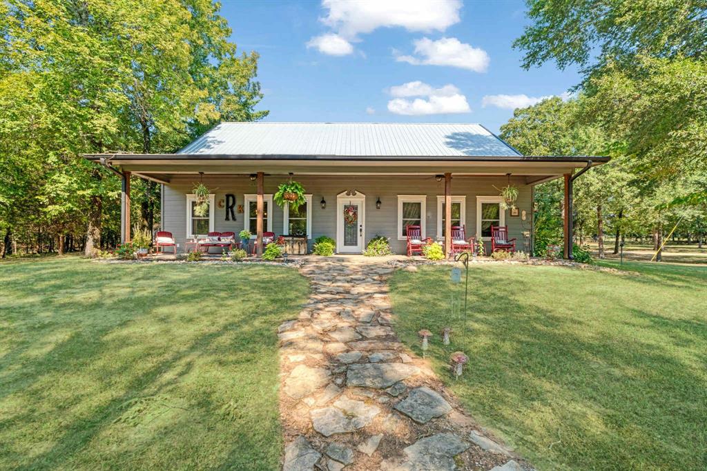 2205 County Road Blossom, TX 75416 - Photo 2 of 27 View of front facade featuring covered porch, a metal roof, and a front lawn