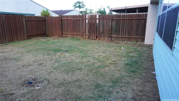 a view of a backyard with wooden fence