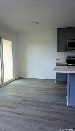 a view of kitchen with wooden floor and electronic appliances