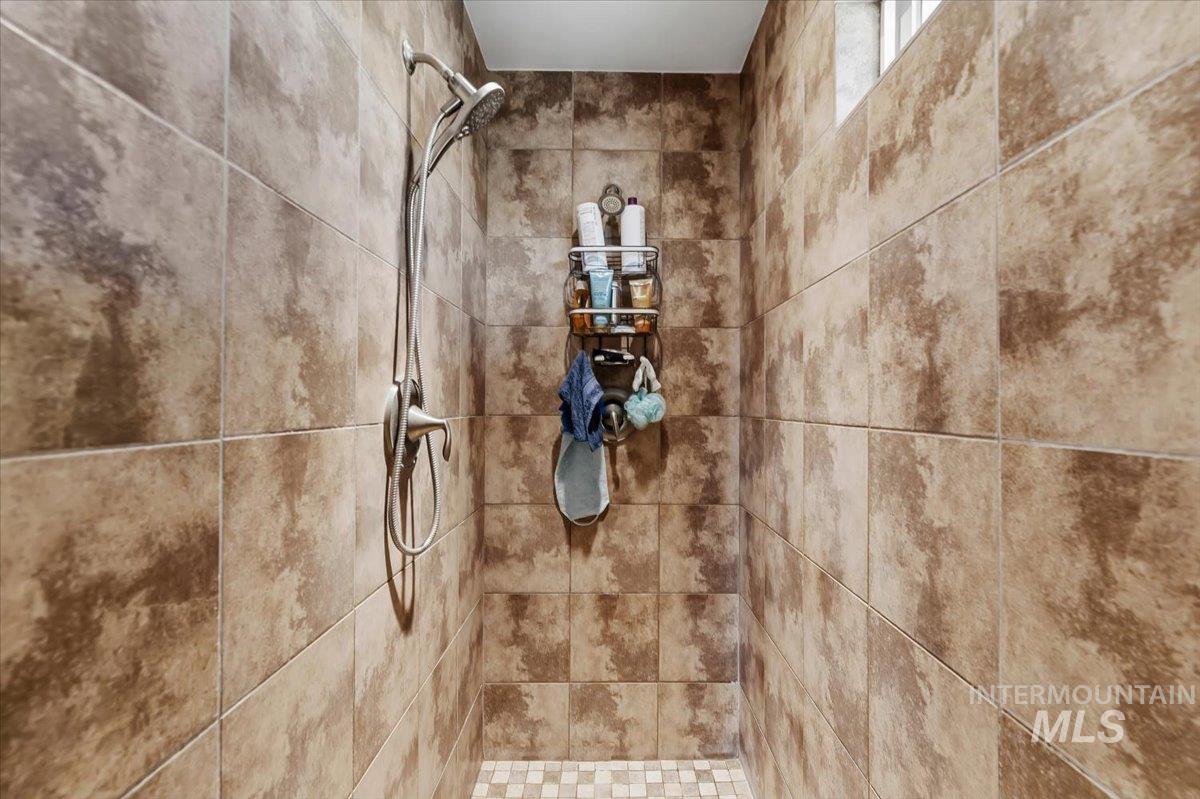 11660 Timber Butte Road Sweet, ID 83670 - Photo 30 of 49 Shower featuring large format wall tiling, a handheld showerhead, and a tiled floor