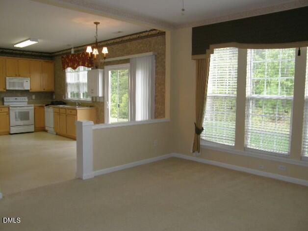 102 Willingham Road Morrisville, NC 27560 - Photo 6 of 19 a view of an empty room with a kitchen and window