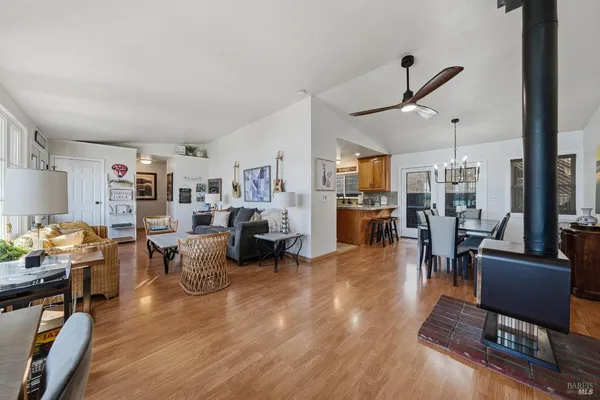 a kitchen with stainless steel appliances granite countertop a refrigerator a stove a sink a dining table and chairs