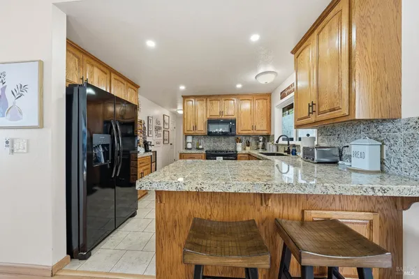 a kitchen with stainless steel appliances granite countertop a sink stove and cabinets