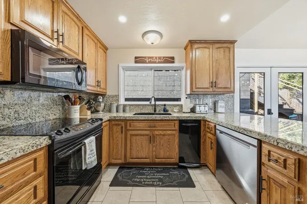 a kitchen with stainless steel appliances granite countertop a refrigerator oven a sink dishwasher and granite countertops