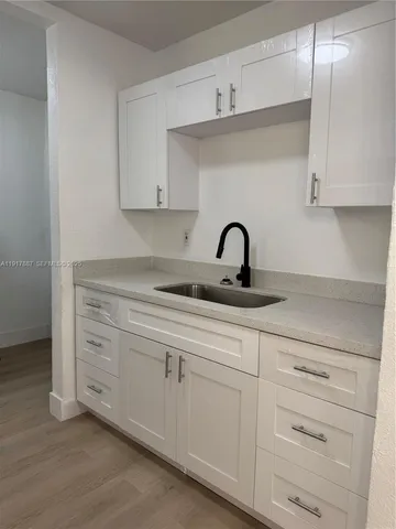 a kitchen with white cabinets stainless steel appliances and sink