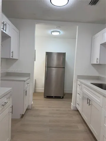 a kitchen with a refrigerator stove and white cabinets