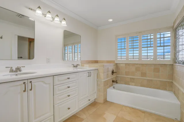 a bathroom with a tub a sink double and mirror
