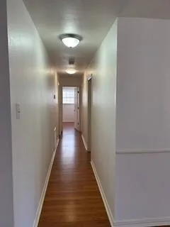 a view of a hallway with wooden floor