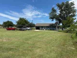 a view of a house with a yard and sitting area