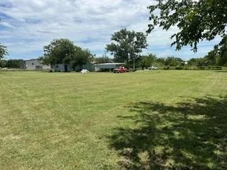 a view of a field of grass and trees