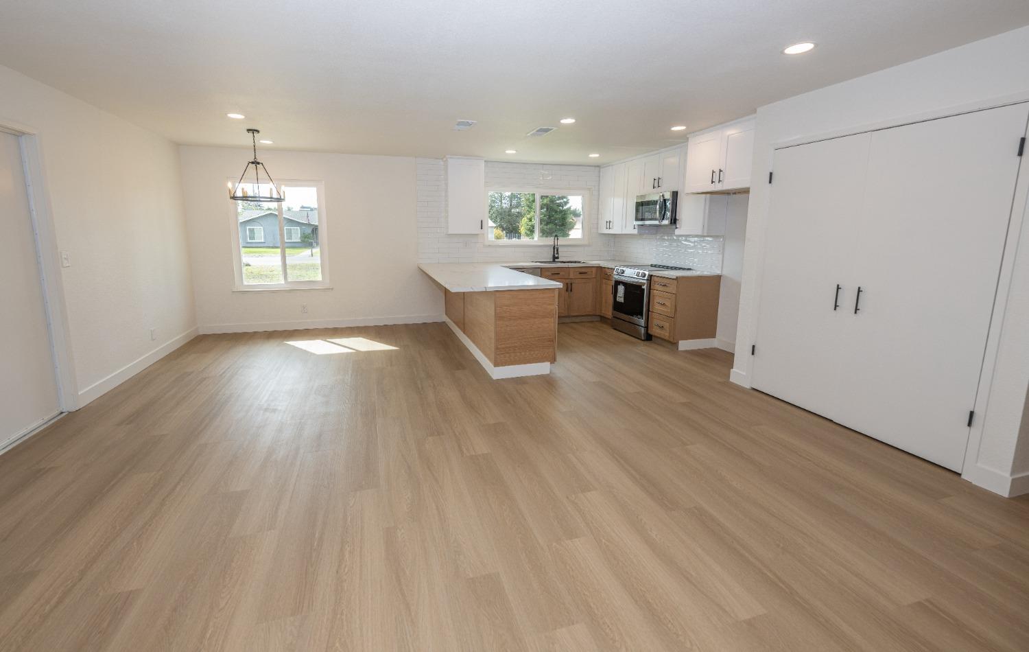 41175 Grove Circle Madera, CA 93636 - Photo 11 of 39 a kitchen with a wooden floor and white appliances