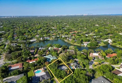 an aerial view of residential houses with outdoor space and trees