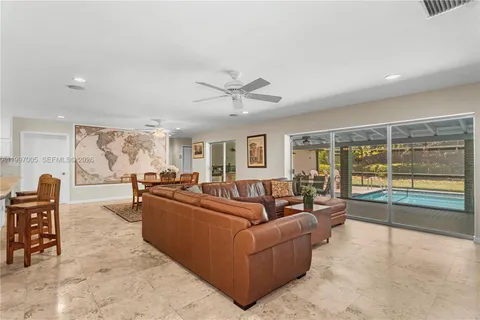 a living room with furniture and a large window with wooden floor