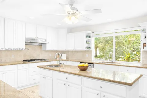 a kitchen with a sink a window and cabinets