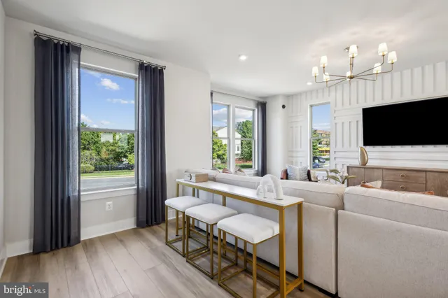 a living room with furniture a flat screen tv and a large window