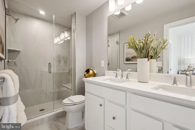 a bathroom with a granite countertop sink a toilet and shower