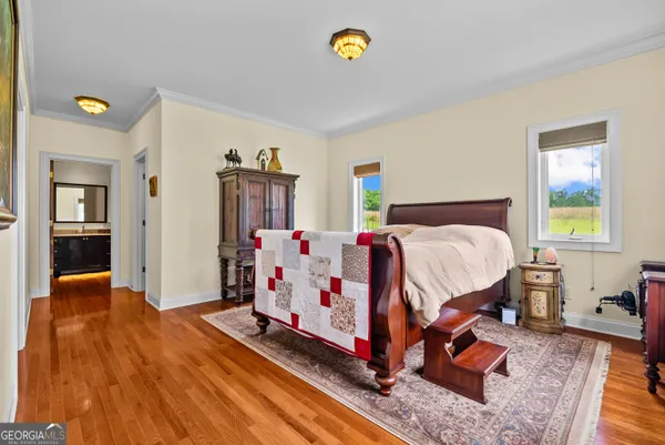a bedroom with a bed and wooden floor